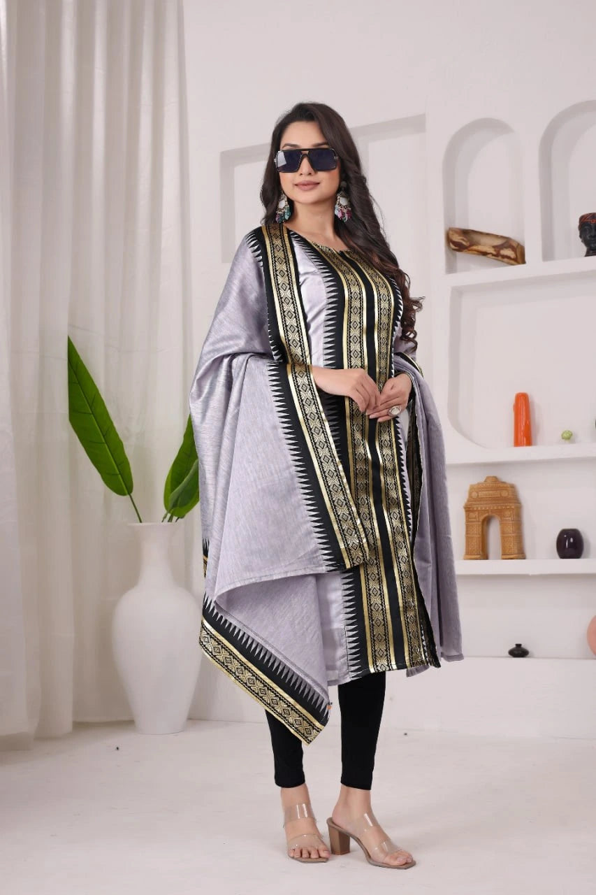 Woman wearing a silver dupatta with a patterned border in a minimalistic setting.