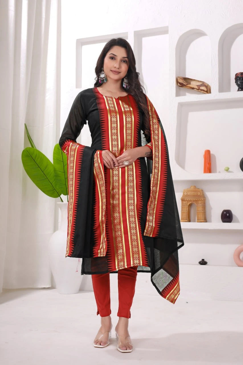 Woman wearing a black, red, and orange traditional outfit in a white room.