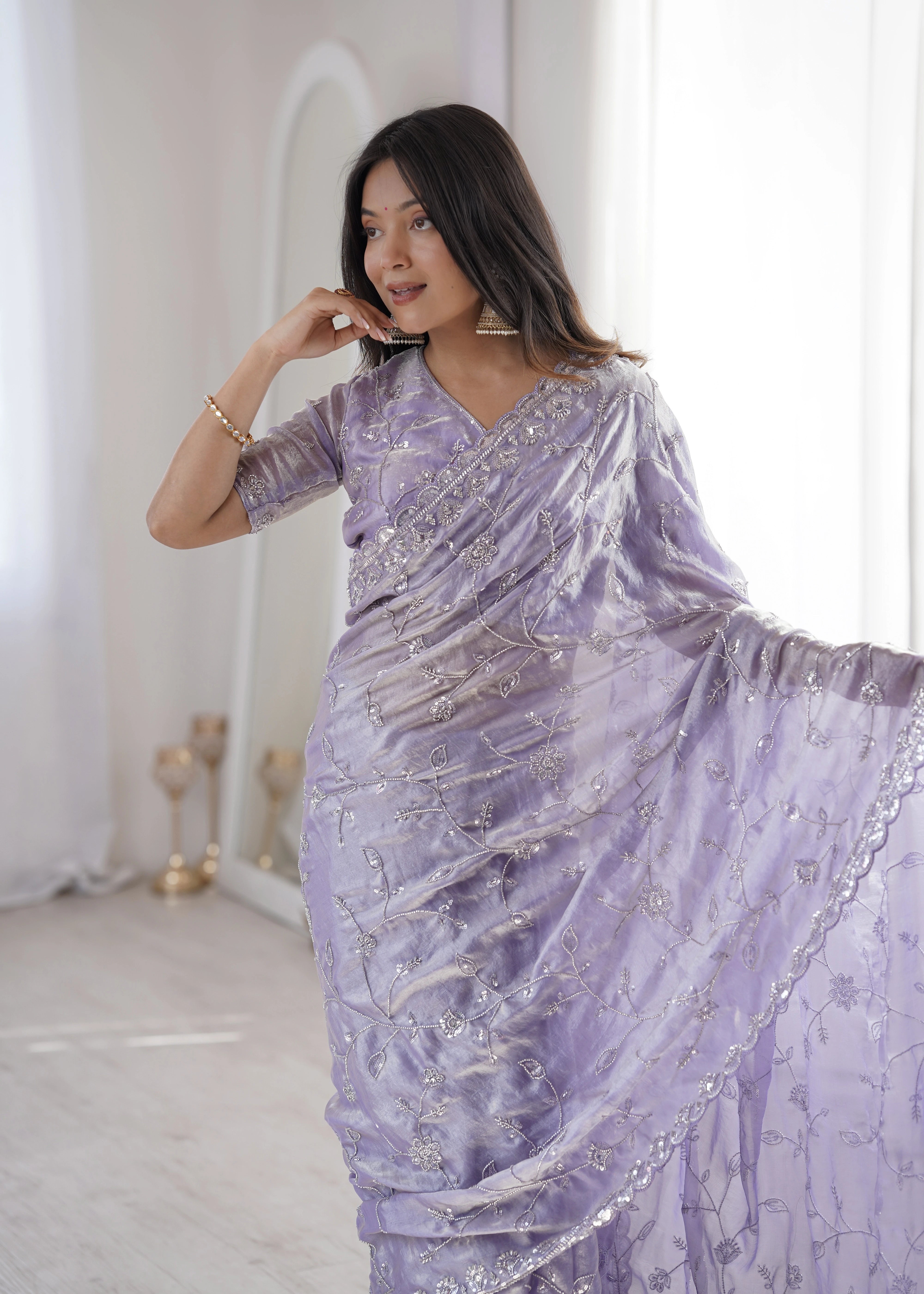 Woman wearing a lavender saree with silver embroidery in a minimalistic setting