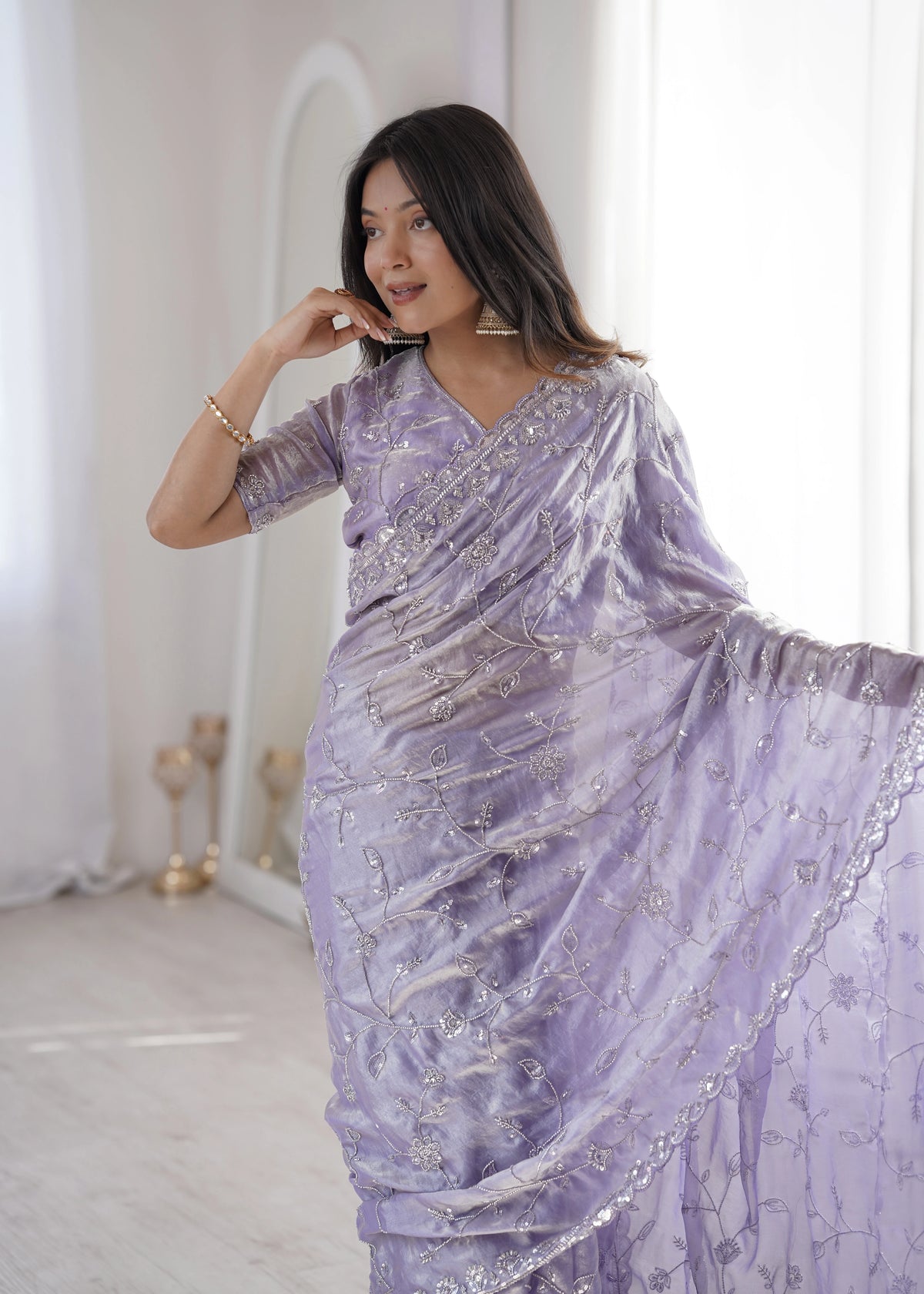 Woman wearing a lavender saree with silver embroidery in a minimalistic setting