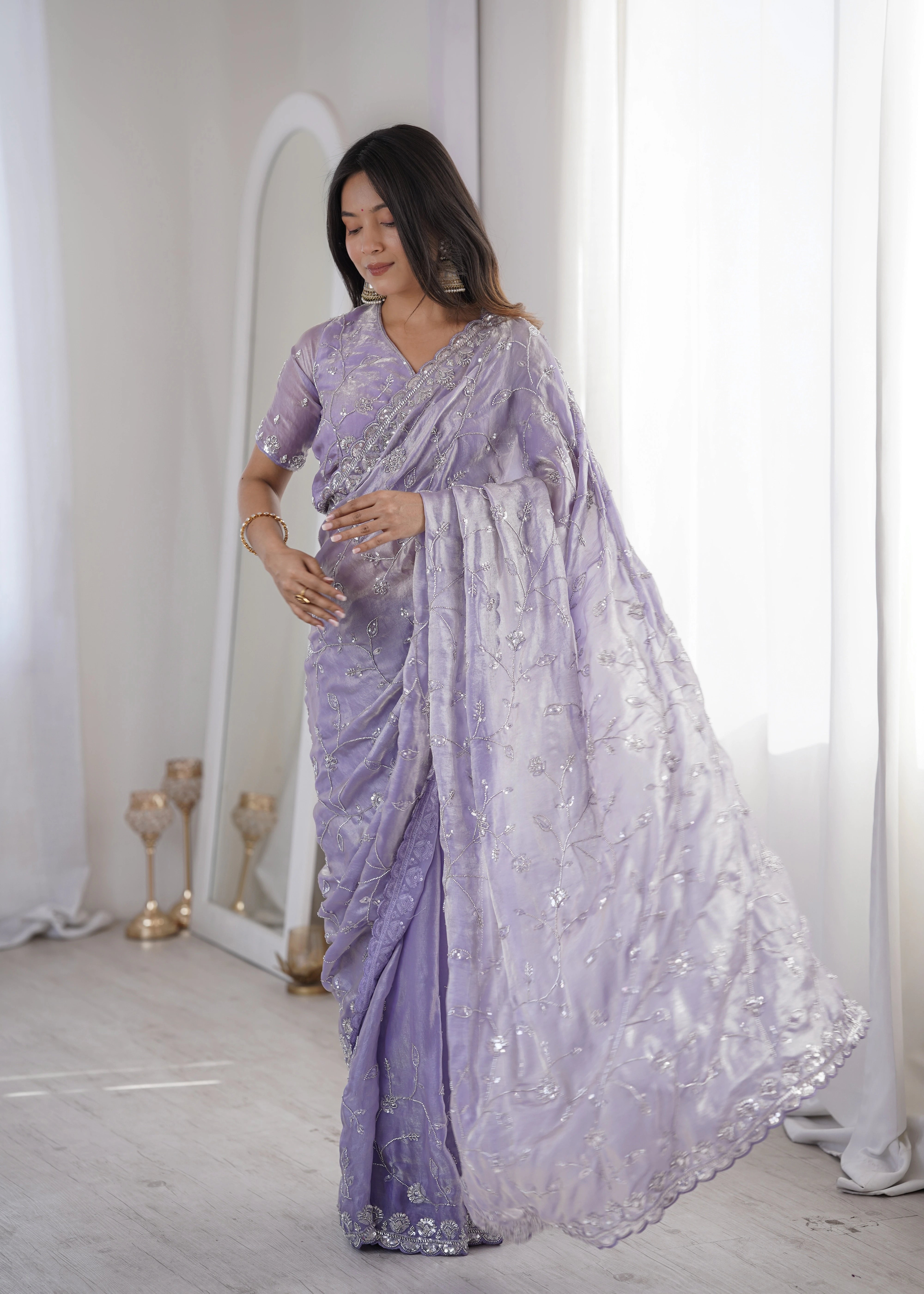 Woman wearing a lavender saree with white embroidery in a minimalistic setting.