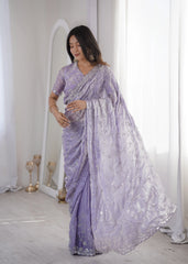 Woman wearing a lavender saree with white embroidery in a minimalistic setting.