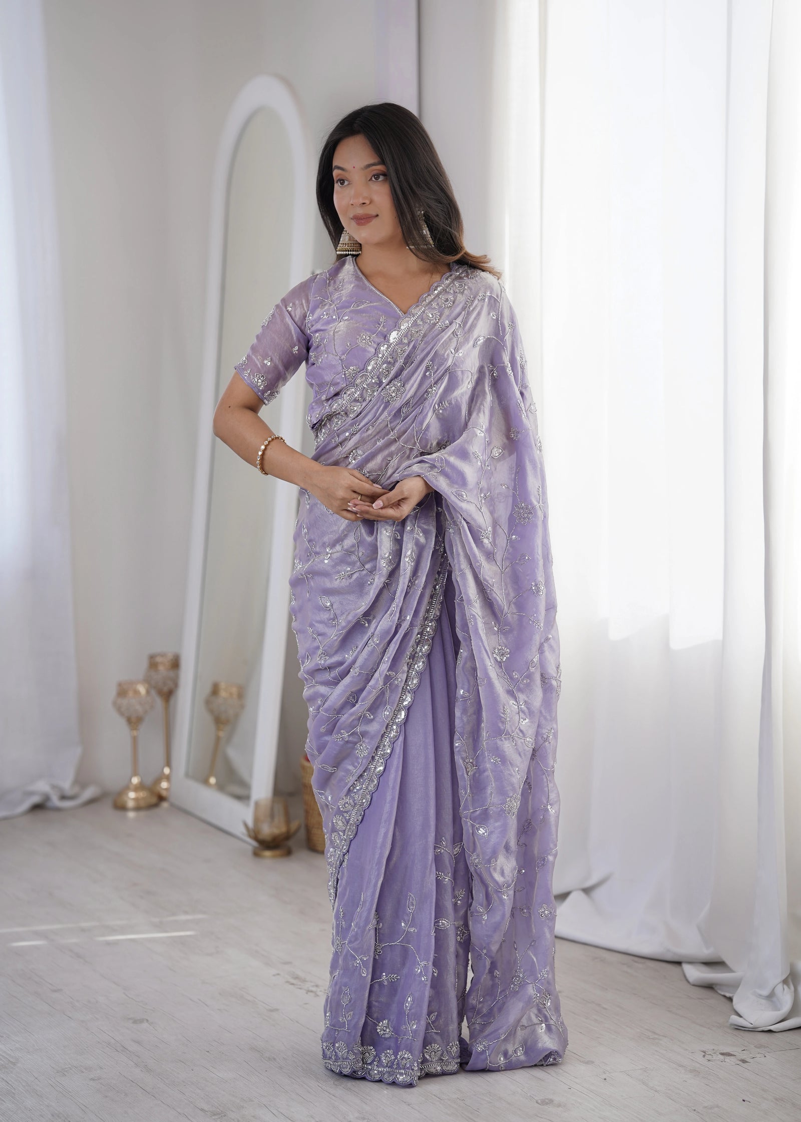 Woman wearing a lavender saree with a white background