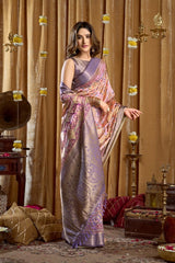 Woman in a saree standing in a decorated room with curtains and decorative items.