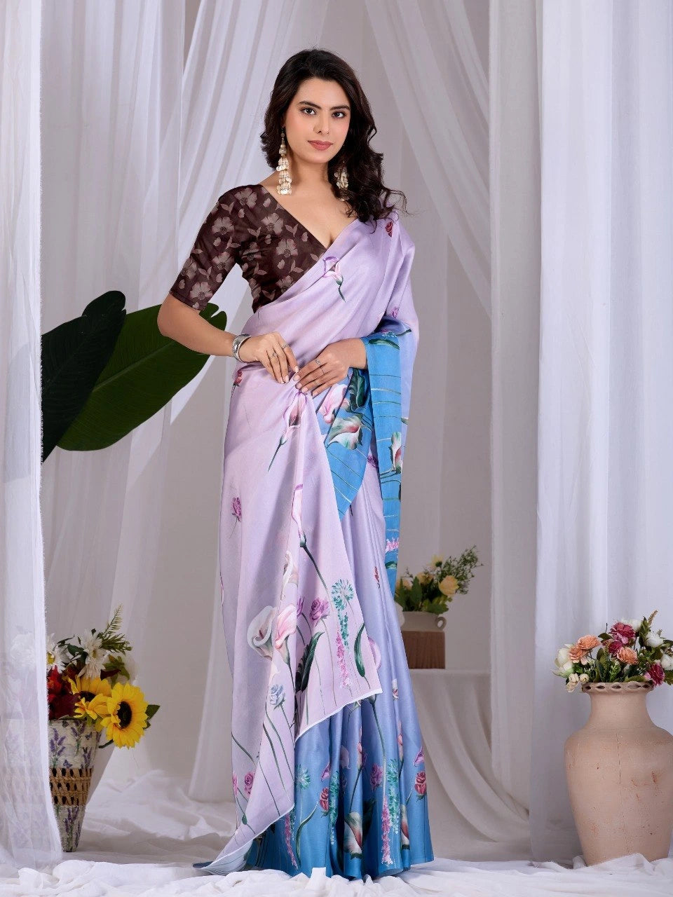 Woman wearing a floral saree with a white curtain background