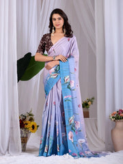 Woman wearing a light purple saree with floral patterns, standing against a white curtain background.