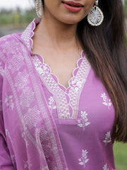 Close-up of a person wearing a purple traditional outfit with white patterns.