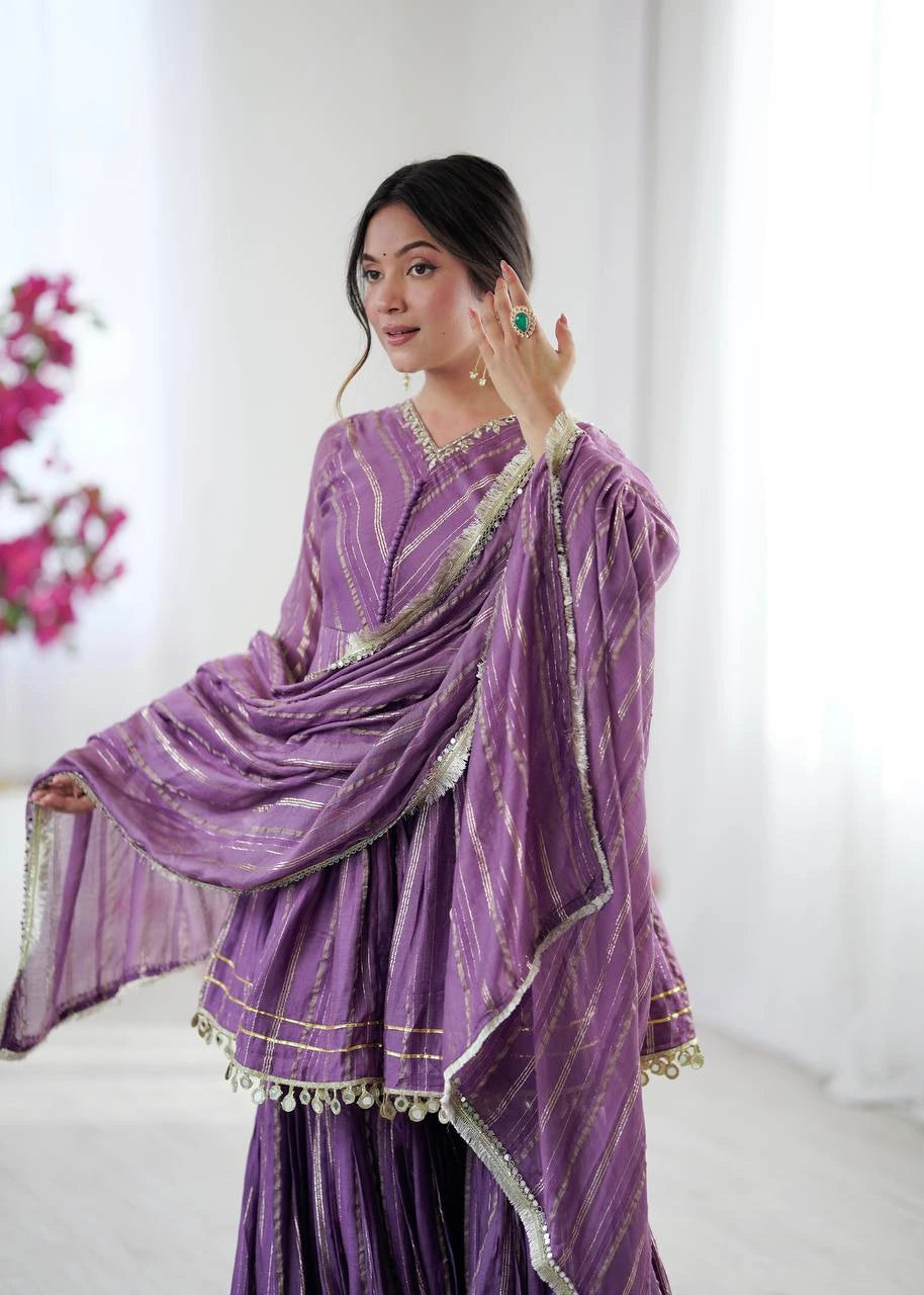 Woman wearing a purple traditional outfit with gold accents against a white background