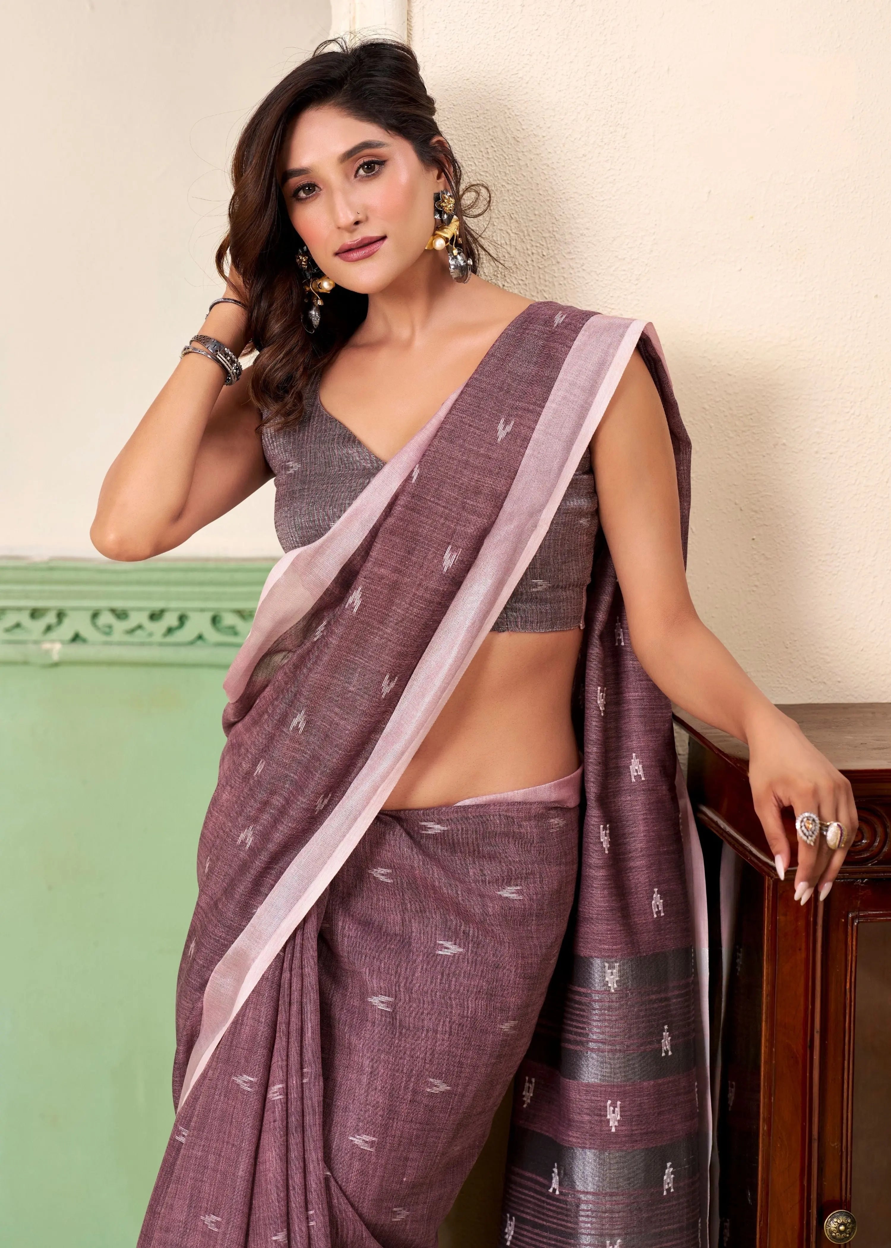 Woman wearing a traditional saree with a plain background