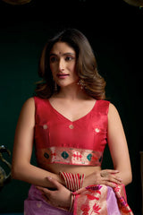 Woman wearing a red blouse with intricate patterns on a dark background