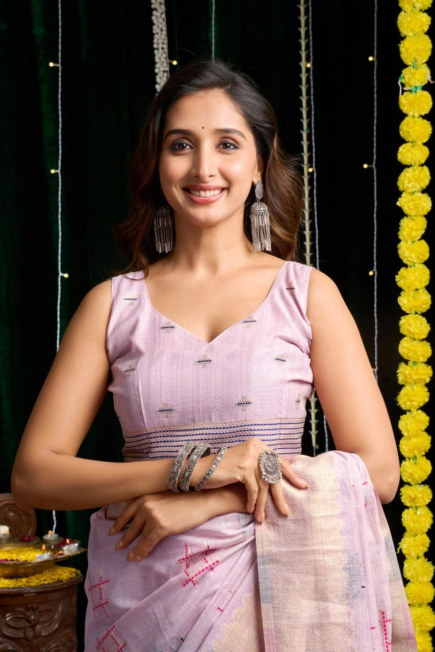 Woman in a light pink saree with a decorative background