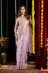 Woman in a light purple saree standing in front of decorative elements