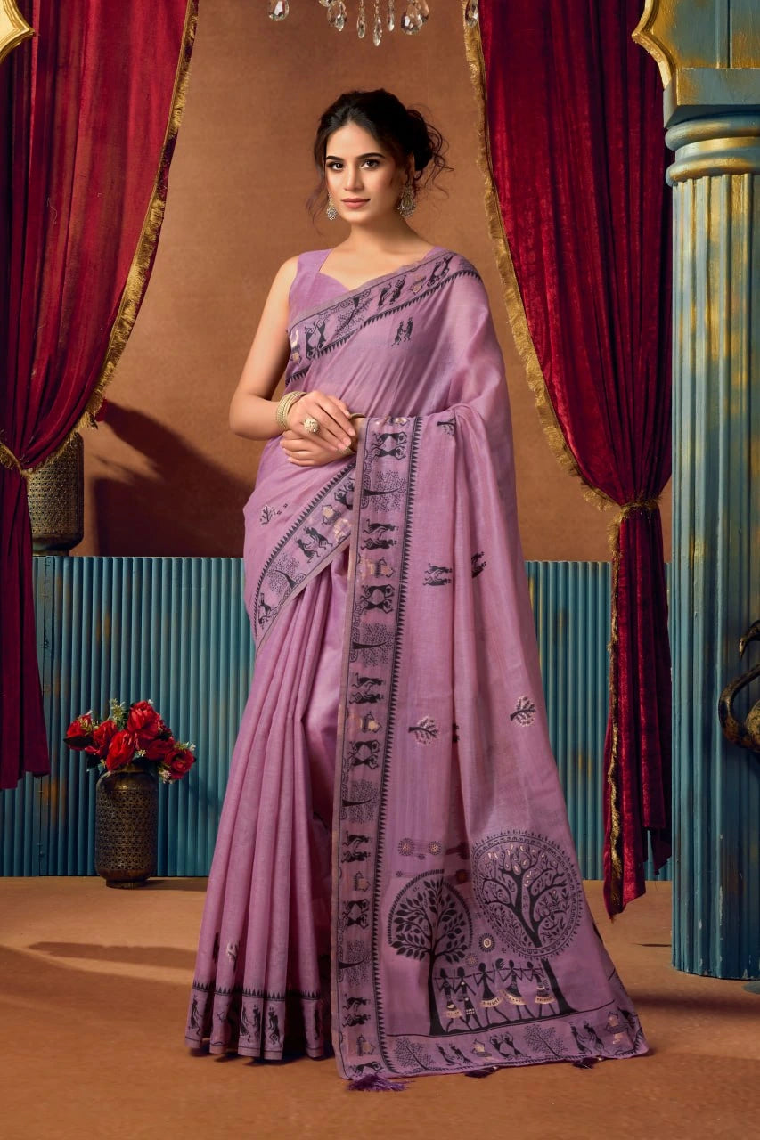 Woman wearing a purple saree with a decorative border in a decorated room.