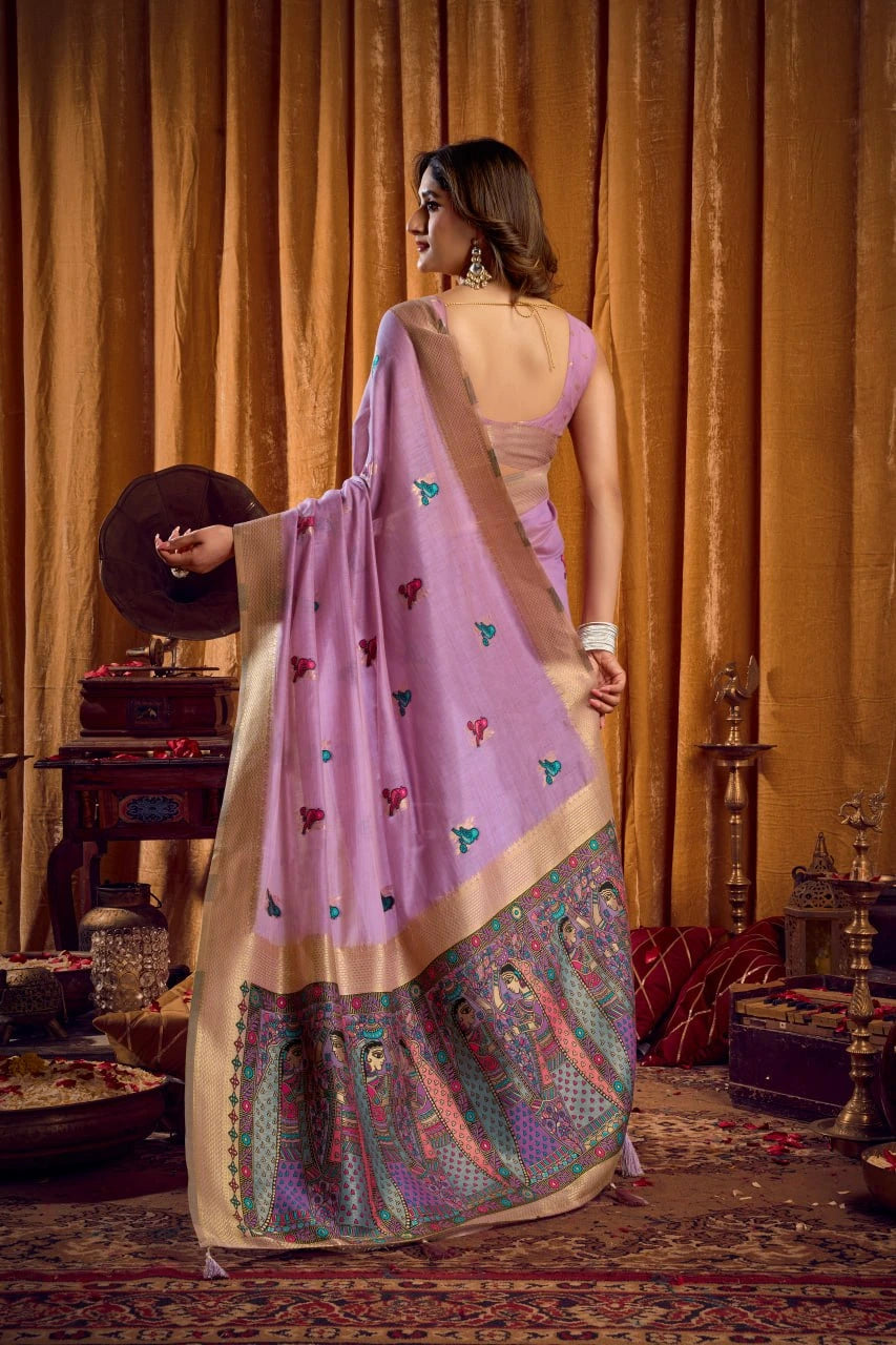 Woman in a traditional outfit with a pink blouse and patterned skirt in a decorated room.