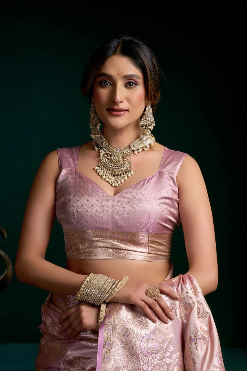 Woman in traditional pink attire with jewelry against a dark background