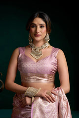 Woman in traditional pink attire with jewelry against a dark background