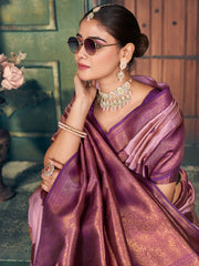 Woman in a purple saree with jewelry and sunglasses, standing outdoors.
