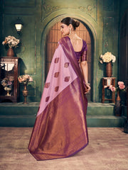 Woman in a traditional saree with a purple blouse and brown saree in an elegant setting.