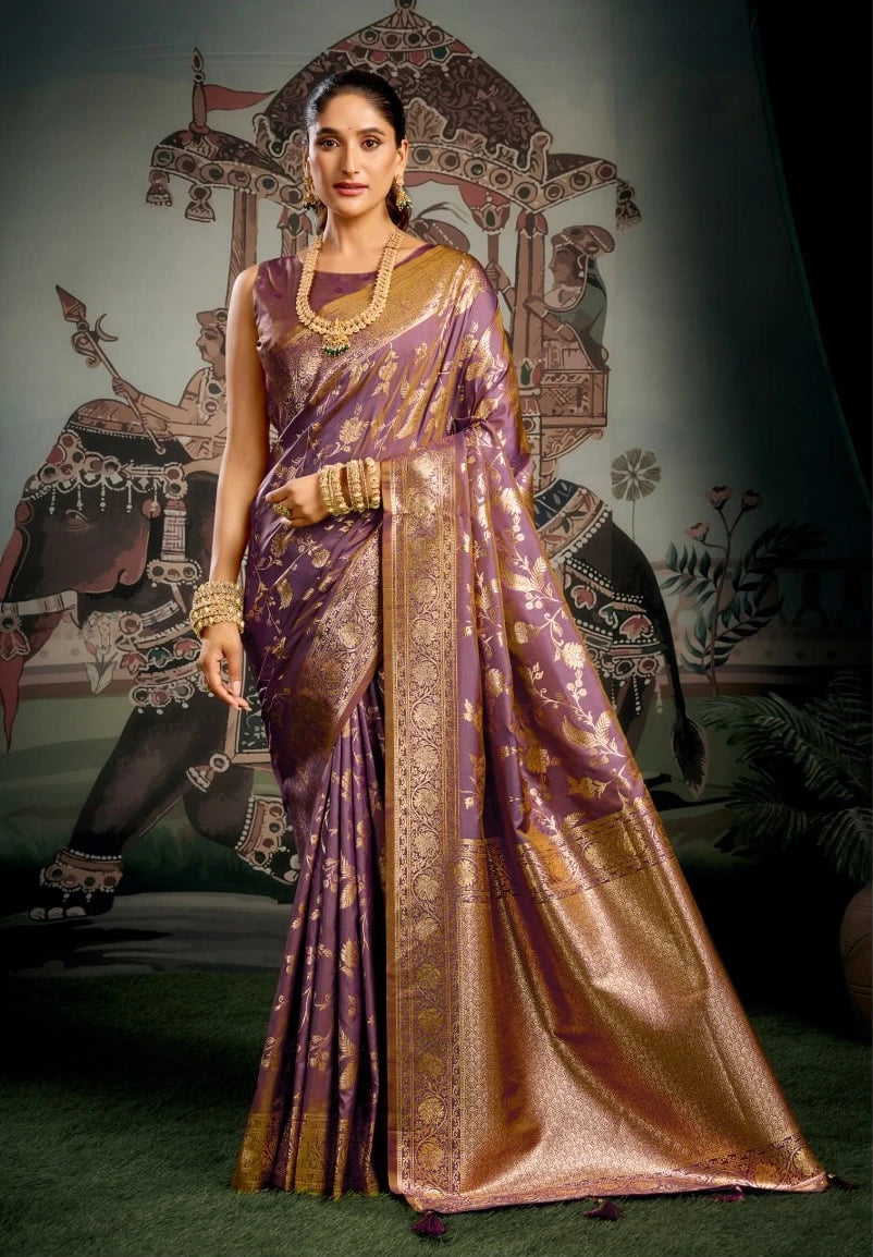 Woman in a traditional purple saree with gold patterns against an artistic background