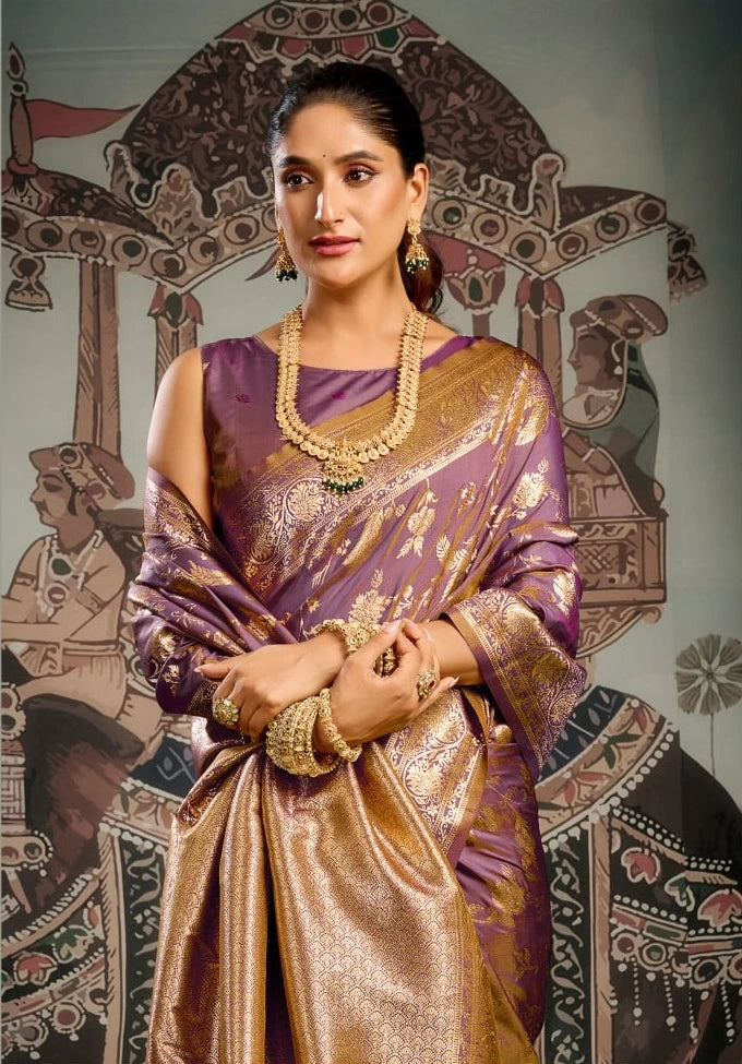 Woman in a traditional purple and gold saree with jewelry against an ornate background