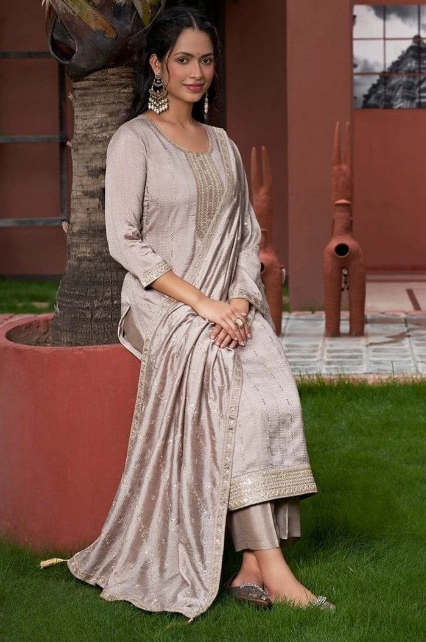 Woman in a traditional outfit sitting on grass next to a tree