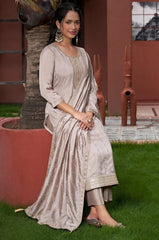 Woman in a traditional outfit sitting on grass next to a tree