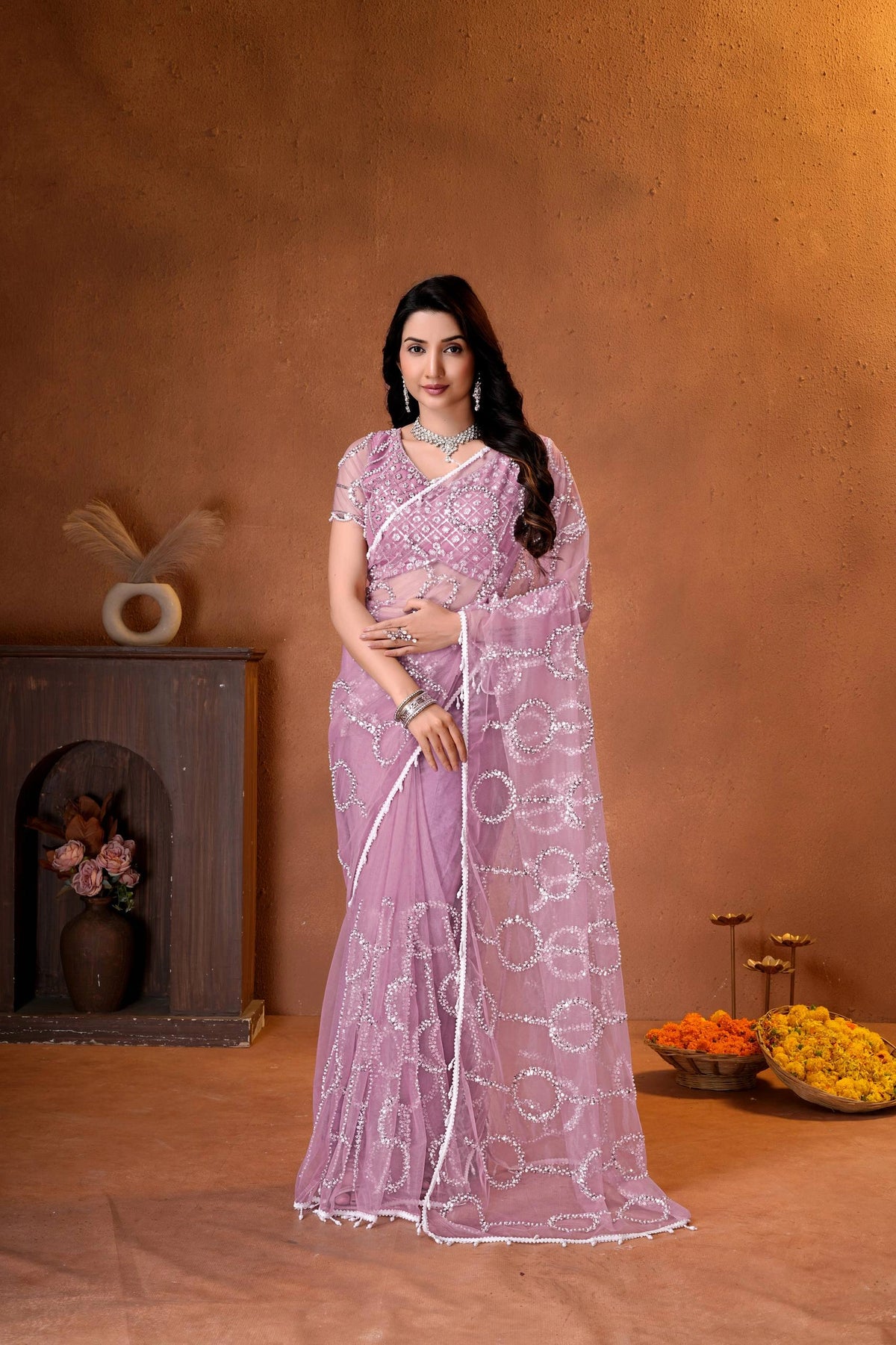 Elegant mauve pink designer saree featuring shimmering sequins embroidery and intricate handcrafted detailing for a graceful festive look.