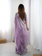 Woman wearing a purple saree with a white background