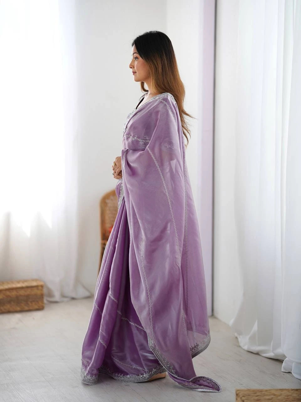 Woman wearing a purple saree with a white background