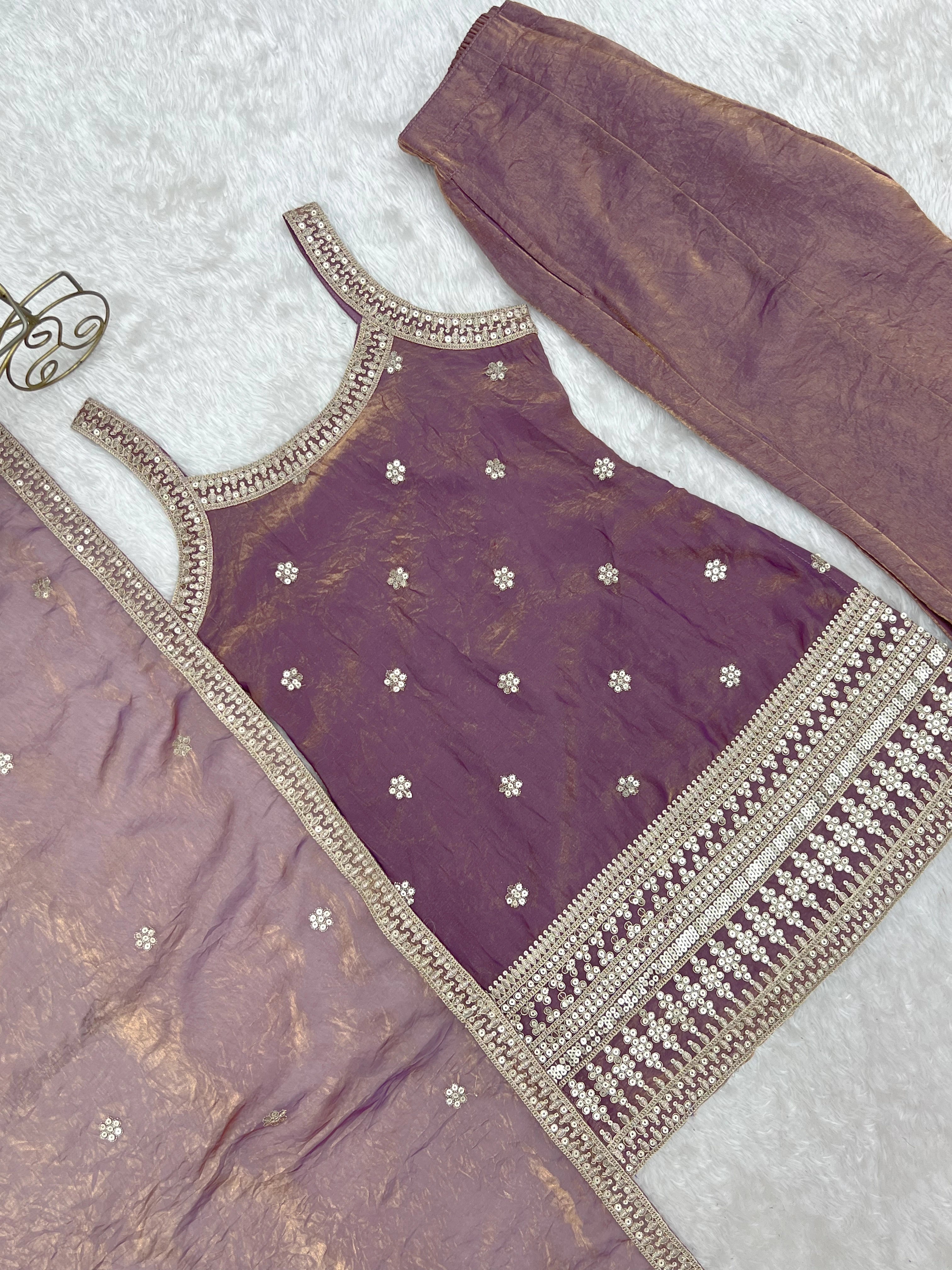 Purple traditional outfit with gold embroidery on a light gray background