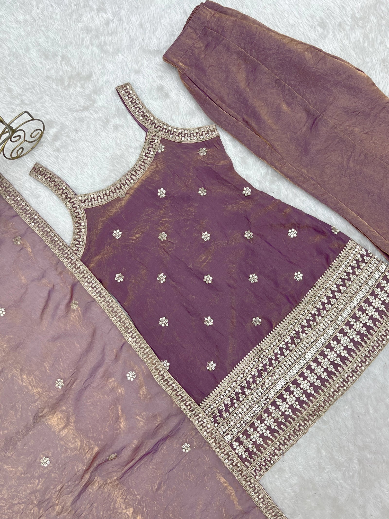 Purple traditional outfit with gold embroidery on a light gray background