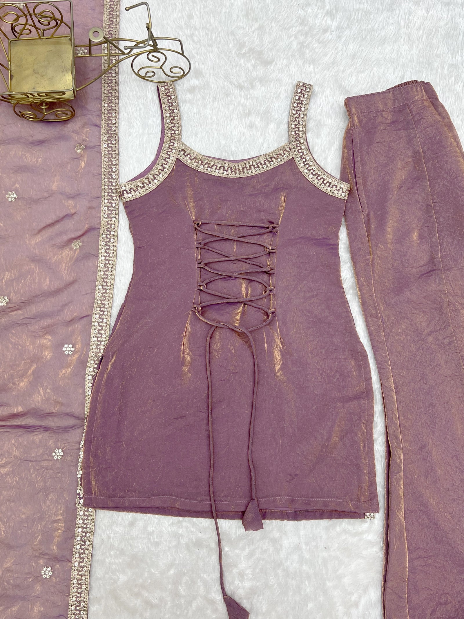 Purple outfit with lace-up design on a textured surface