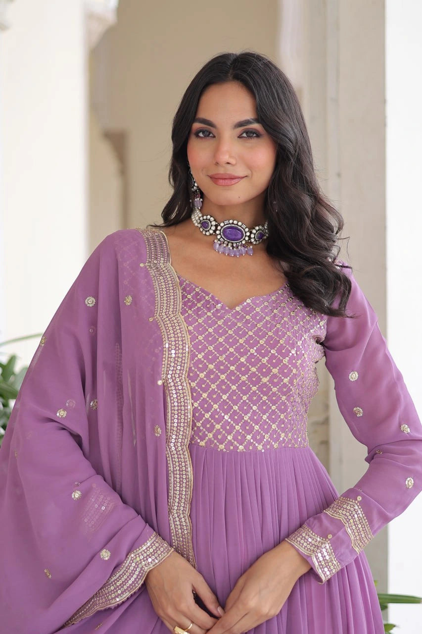 Woman wearing a purple traditional outfit with intricate designs.