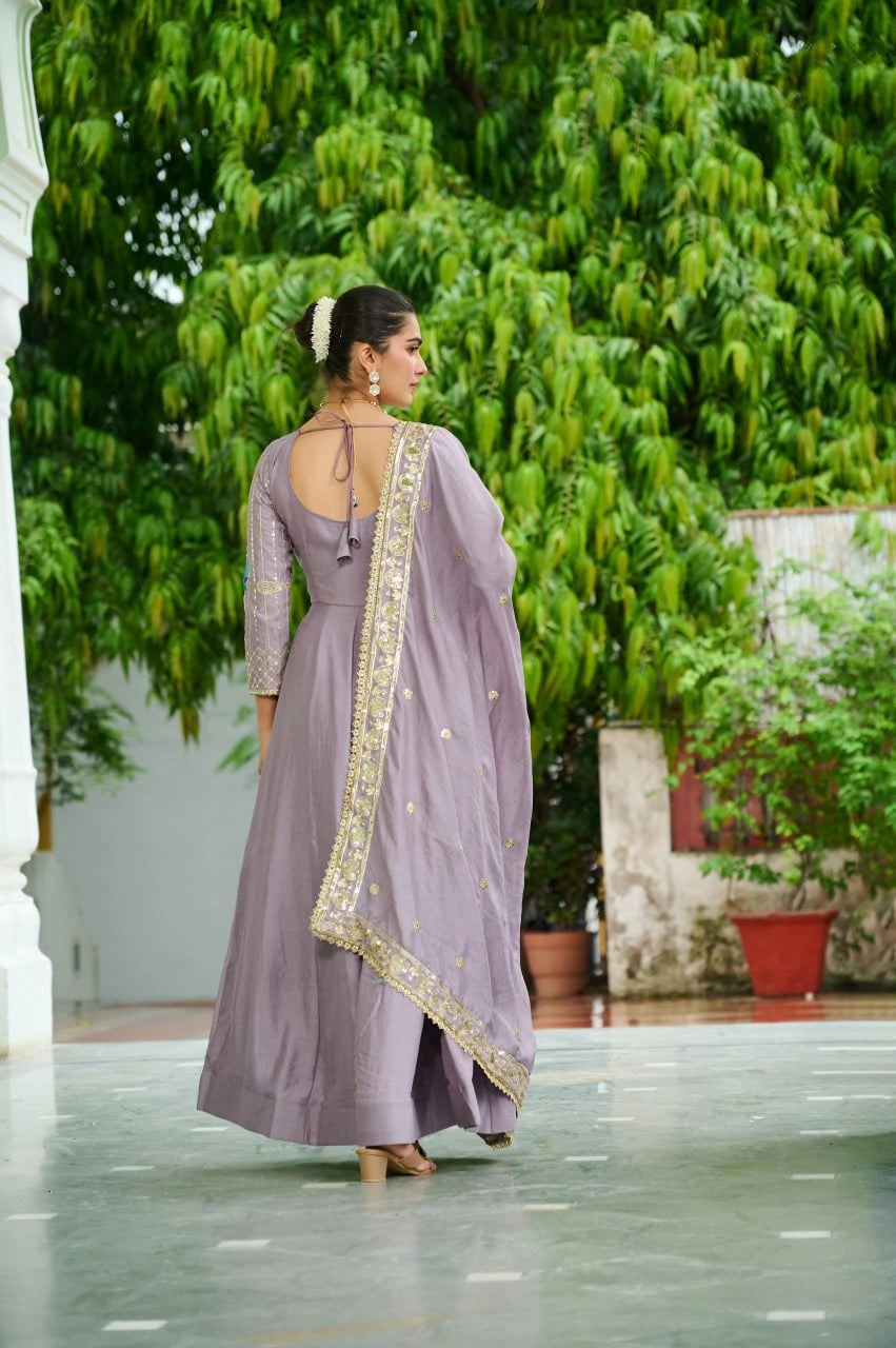 Woman in a lavender traditional outfit with a saree walking outdoors.