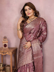 Woman in a traditional saree posing against a pink background