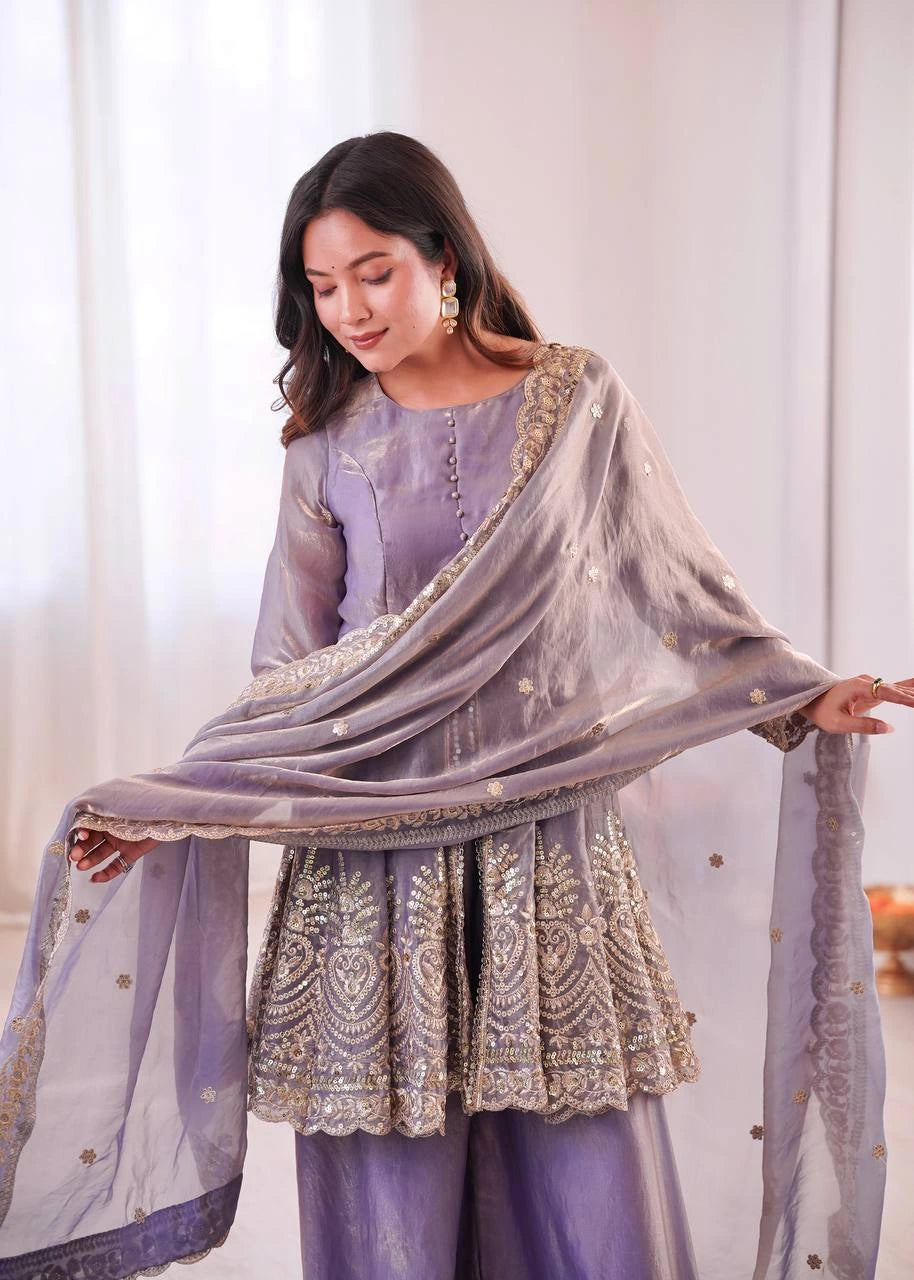 Woman wearing a light purple embroidered outfit with a matching dupatta in a well-lit room.