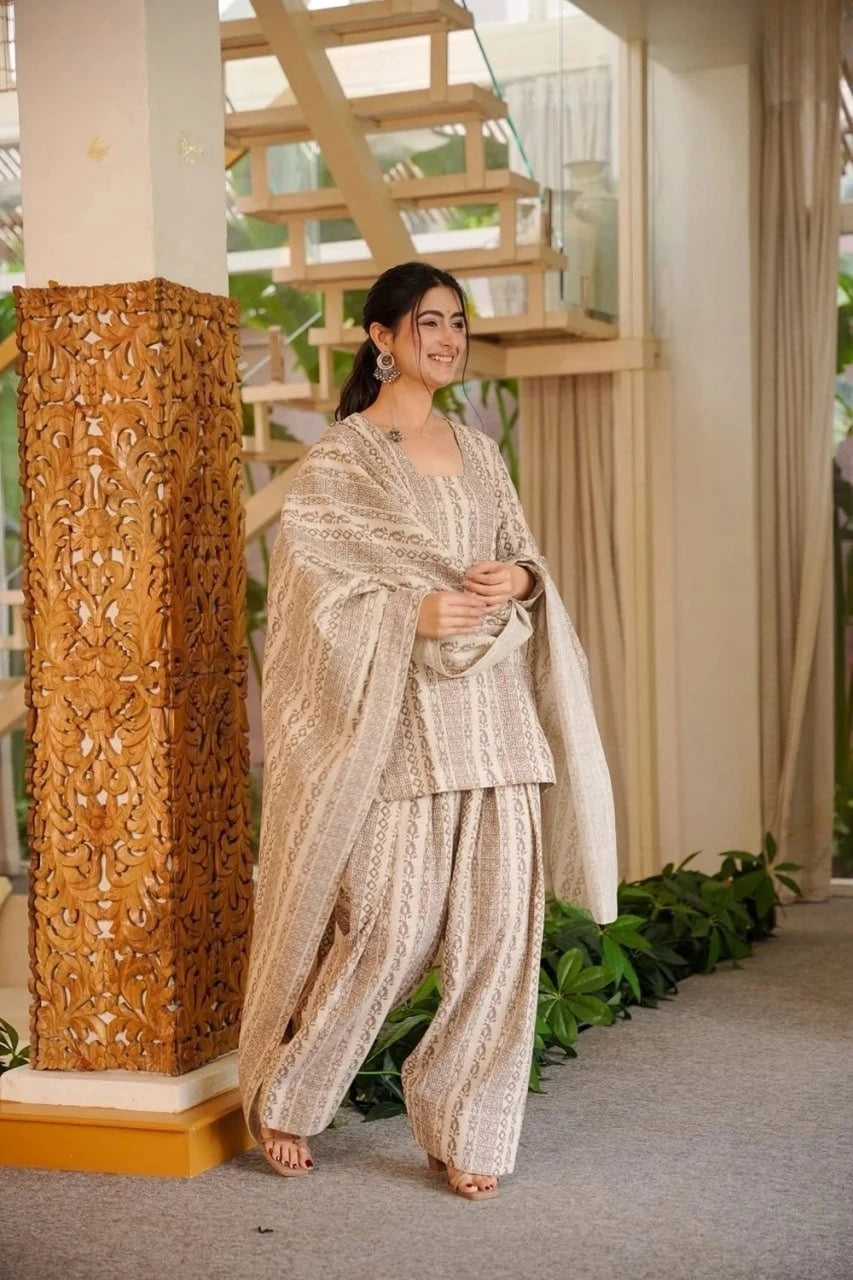 Woman in traditional outfit standing next to a decorative column indoors
