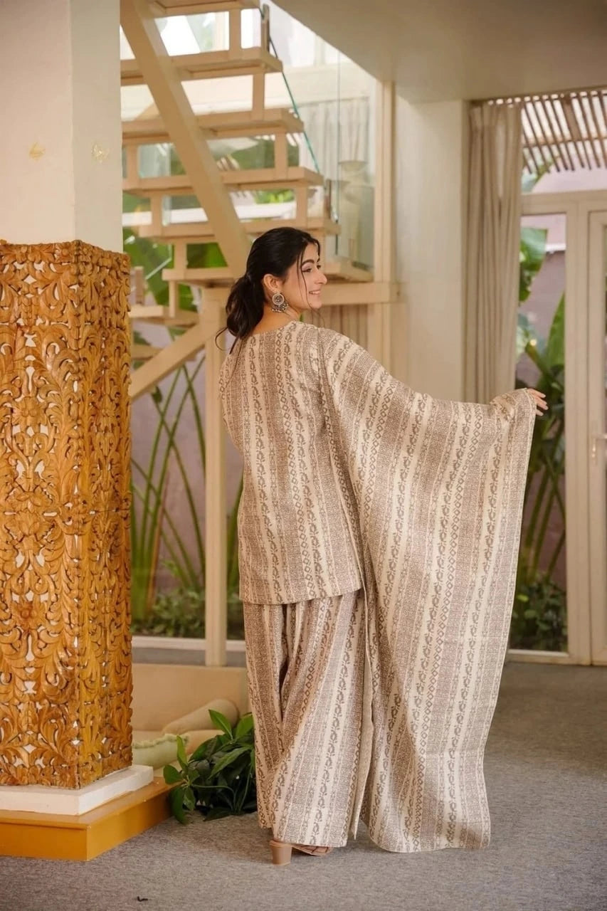 Woman in a traditional outfit standing in a well-lit room with decorative elements.