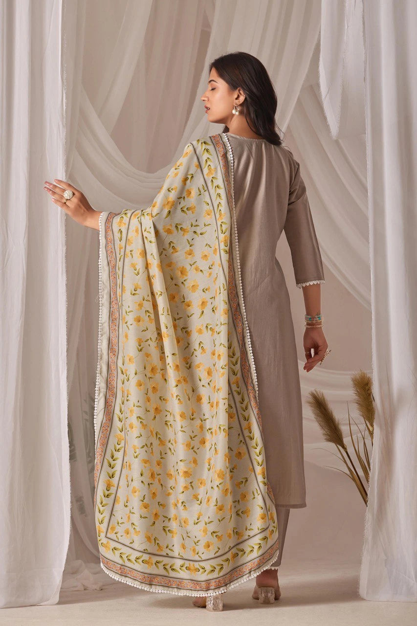 Woman wearing a beige outfit with a floral dupatta against a neutral background