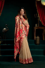 Woman wearing a saree with a red and beige pattern on a dark background