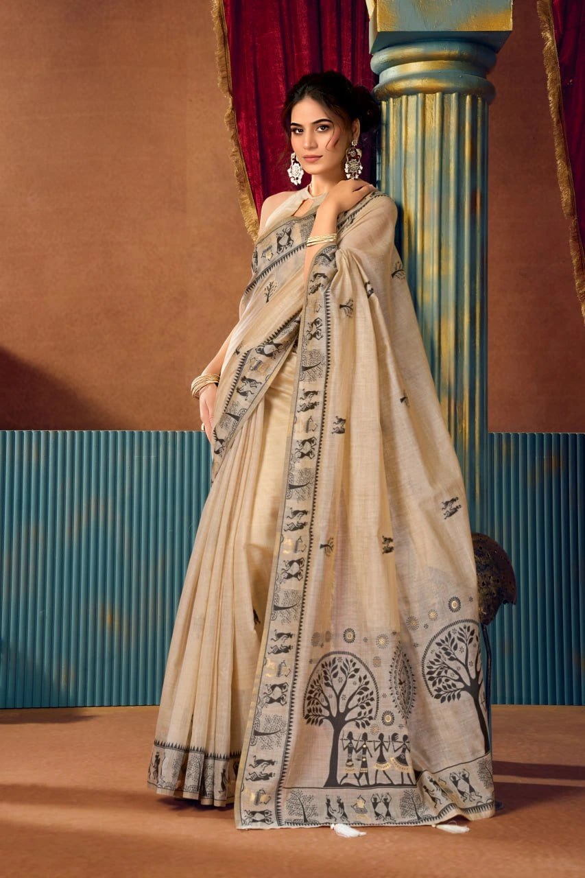 Woman wearing a traditional beige saree with black patterns in an ornate setting.