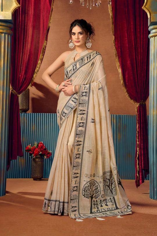 Woman wearing a traditional saree with intricate patterns in a decorative setting.