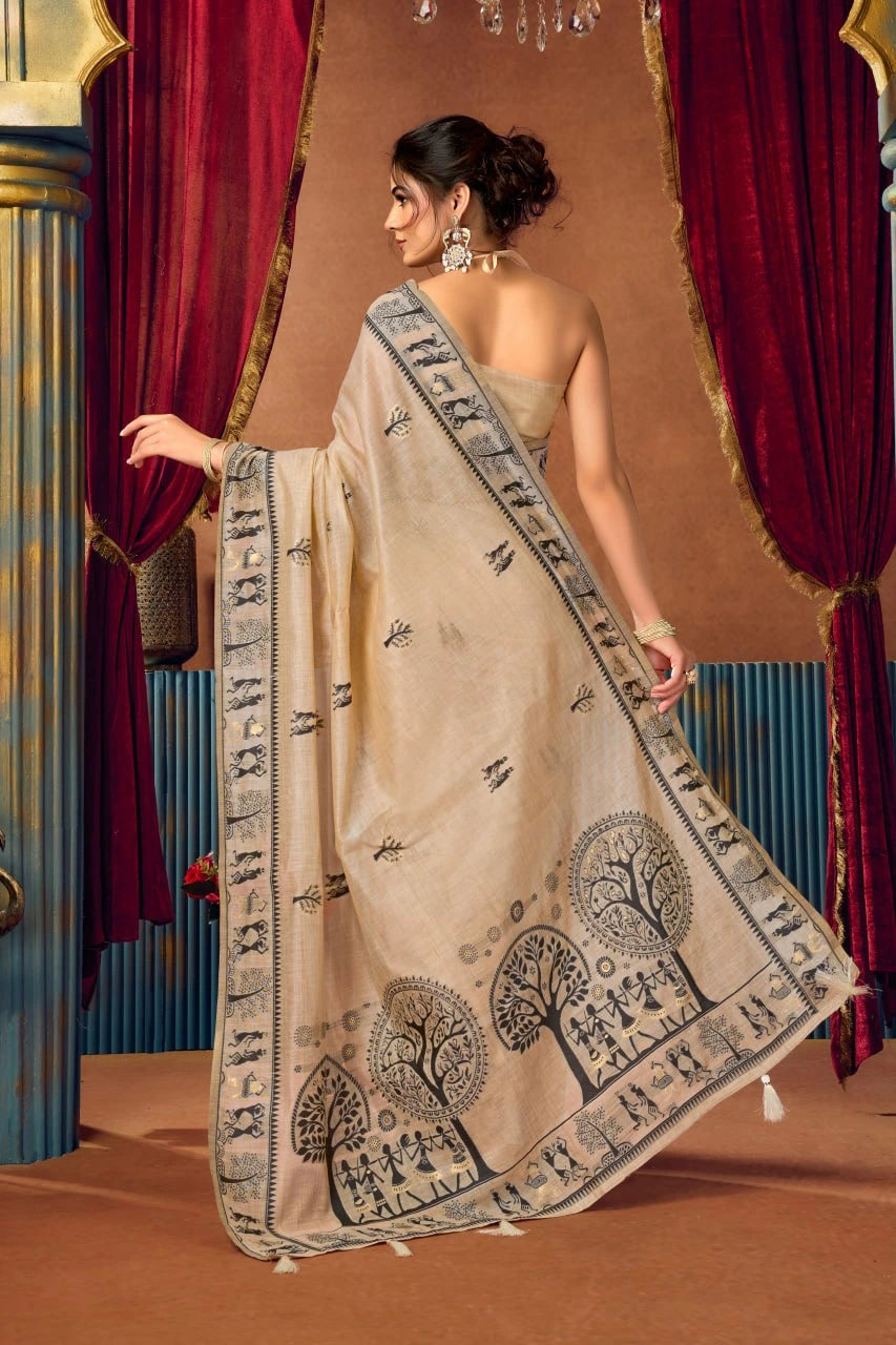 Woman wearing a beige saree with black patterns in front of red curtains.