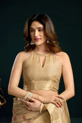 Woman wearing a gold traditional outfit against a dark background