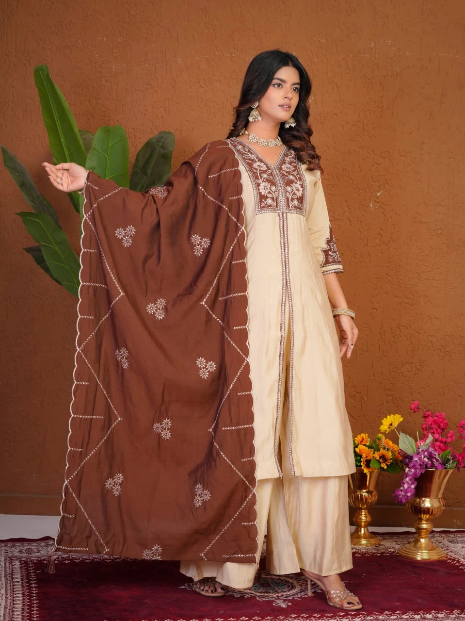 Woman in a traditional outfit with brown and beige dress against a brown background