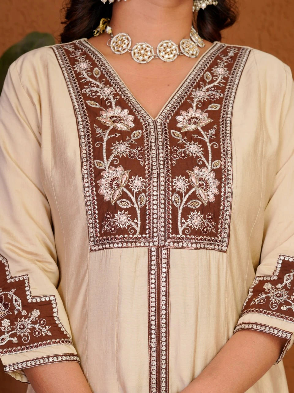 Beige kurta with brown floral embroidery on a plain background