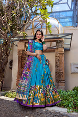 Beautiful sky blue Kalamkari print saree featuring a vibrant purple pallu and ethnic floral motifs.