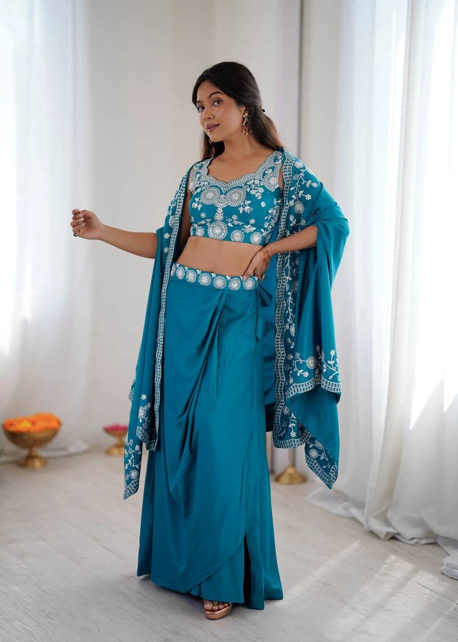 Woman wearing a blue traditional outfit with white embroidery in a bright room.