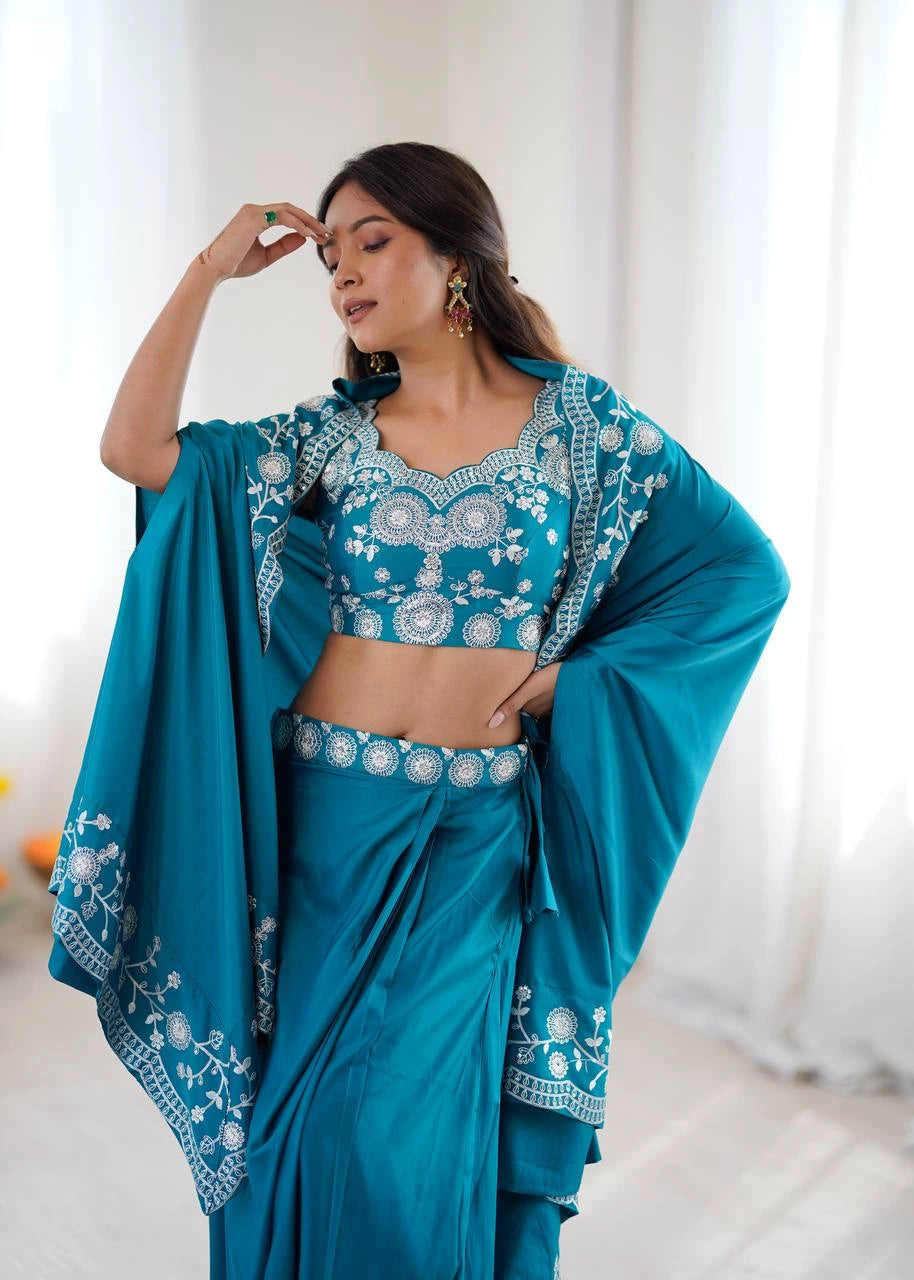 Woman wearing a teal saree with white embroidery against a white background