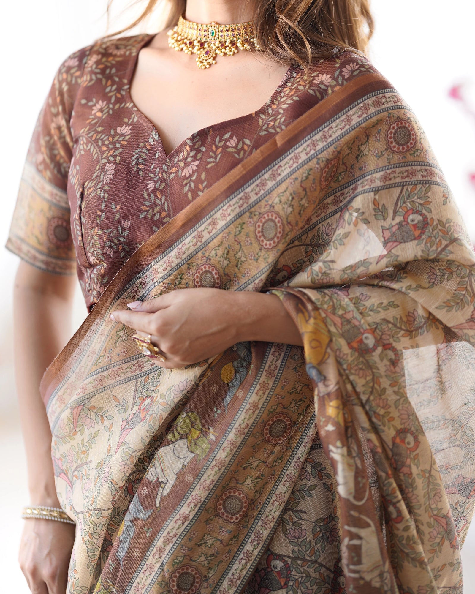 Woman wearing a patterned saree with a blurred background